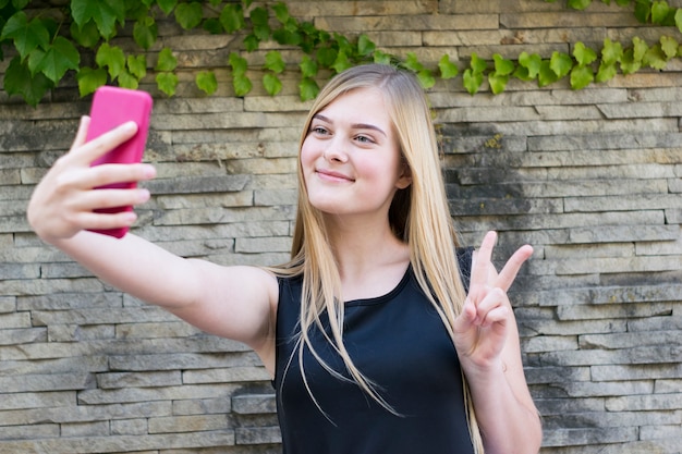 Glimlachende dame met roze telefoon