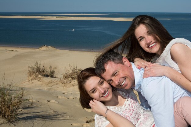 Glimlachende familie die hun dochter meelift op het strand