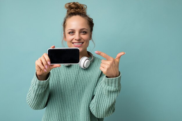 Foto glimlachende gelukkige mooie jonge vrouw die er goed uitziet in een casual outfit die geïsoleerd staat op