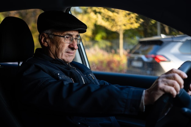 Glimlachende gelukkige oudere man in de nieuwe auto