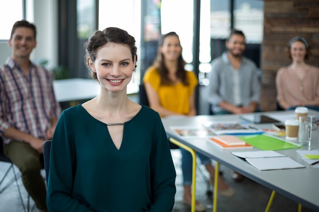 Glimlachende grafische ontwerpers die in bureau zitten