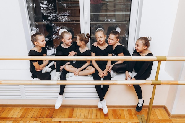 Glimlachende gymnasten die op het raam zitten en lachen en samen, teamgeest, samenwerkingsconcept