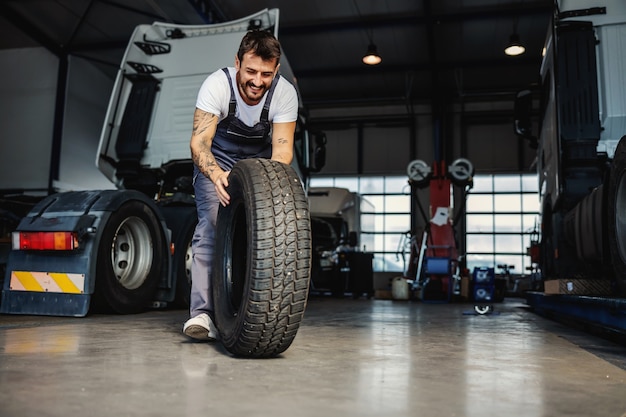 Glimlachende hardwerkende mechanische rollende band om deze op de vrachtwagen te veranderen