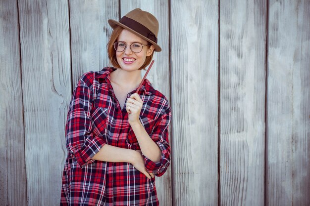 glimlachende hipster vrouw die een potlood houdt,