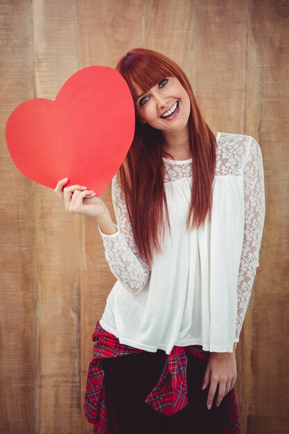 Glimlachende hipster vrouw met een groot rood hart