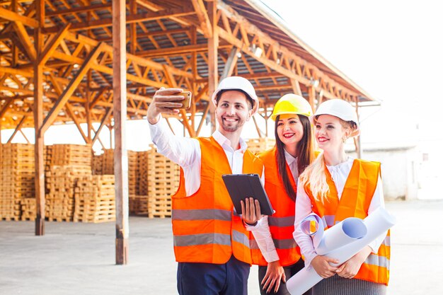 Glimlachende ingenieurs nemen selfie op bouwplaats. Succesvol teamwerkconcept