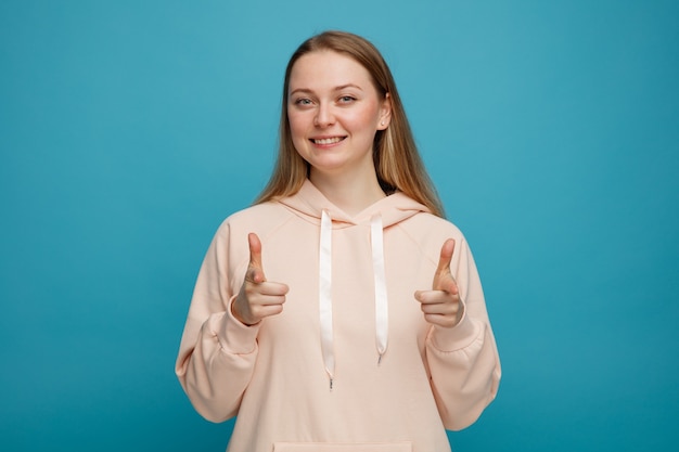 Glimlachende jonge blonde vrouw die je gebaar doet