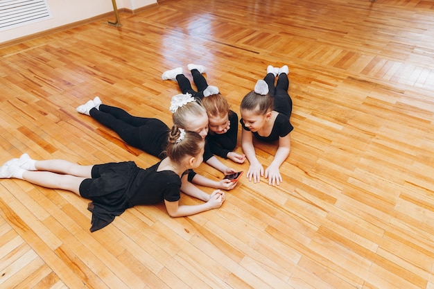 Glimlachende jonge gymnasten die naar de telefoon kijken voor de yogatraining