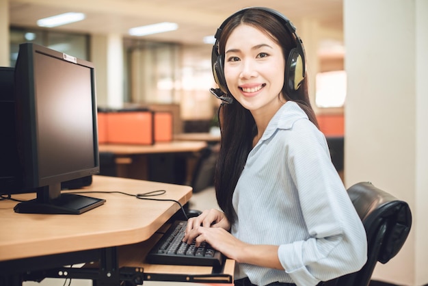 Glimlachende jonge klantenservicevertegenwoordiger die met een headset praat