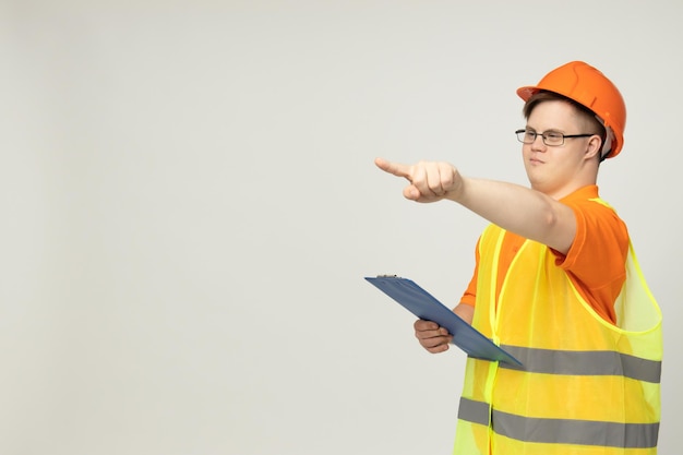 Glimlachende jonge man met Down-syndroom in bril in werkuniform met kassa op het hoofd plaats voor tekst