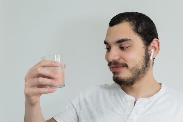 Glimlachende jonge mens met smoothieglas