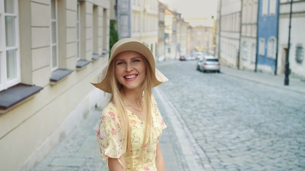 Glimlachende jonge vrouw die op straat loopt