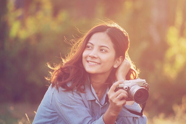 Foto glimlachende jonge vrouw met een camera.