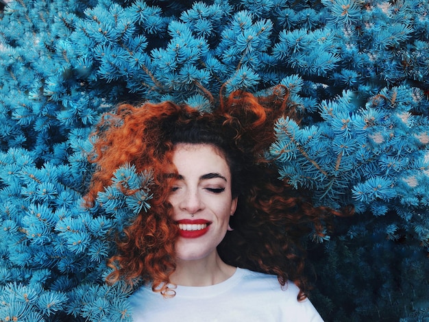 Glimlachende jonge vrouw te midden van de boom