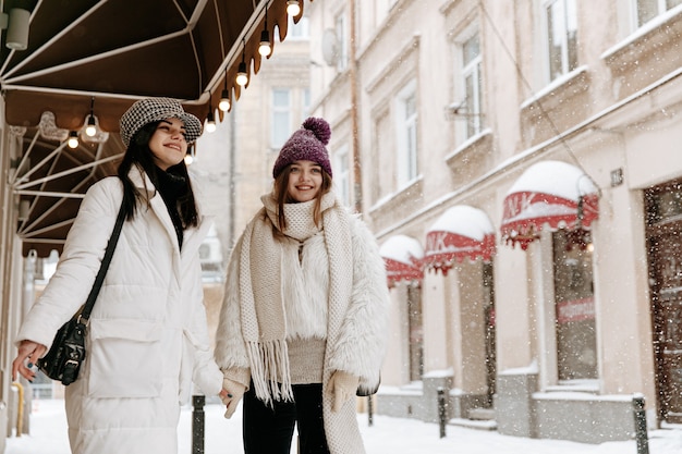 Glimlachende jonge vrouwen die warme de winterkleding dragen chatten