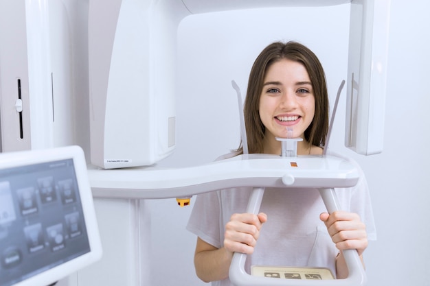 Glimlachende jonge vrouwen geduldige status in x-ray machine
