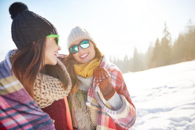 Glimlachende jonge vrouwen in de sneeuw