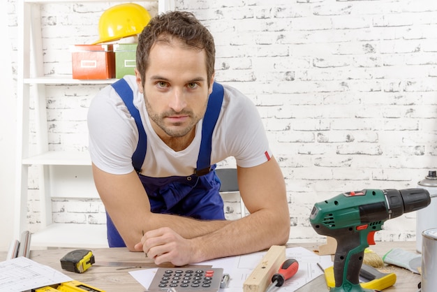 Glimlachende jonge werknemer in zijn workshop