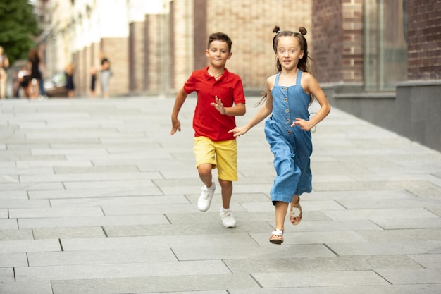 Glimlachende jongen en meisje lopen samen in de stad in de zomerdag