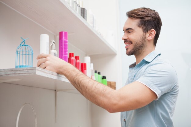 Glimlachende kapper met haarproducten