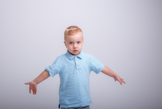 Glimlachende kleine jongen die blauw overhemd draagt