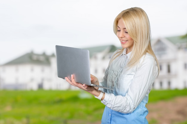 Glimlachende laptop van de vrouwenholding