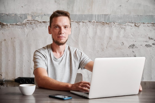 Glimlachende man aan het werk in laptop thuis