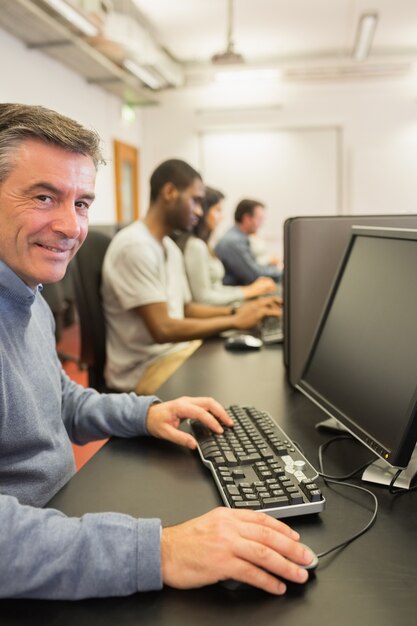 Glimlachende man aan het werk met de computer