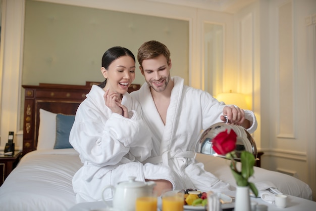 Glimlachende man en vrouw die ontbijt in het hotel hebben