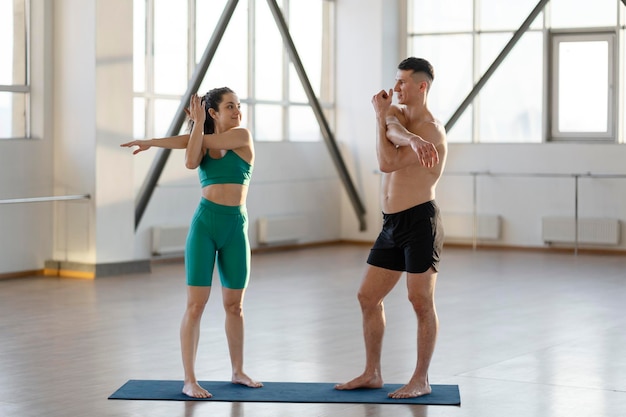 Glimlachende man en vrouw die samen trainen voordat ze binnenshuis trainen in de sportschool