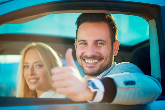 Glimlachende man en vrouw in een nieuwe auto
