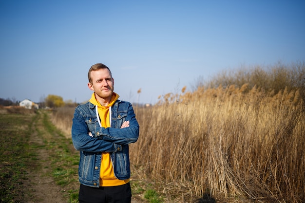 Glimlachende man genieten van wind waait in het bos. Gelukkige man die vreugde voelt tijdens het wandelen in de natuur, vrije ruimte op de achtergrond van groene bomen. Levensliefde, vreugde, frisse lucht, renovatieconcept