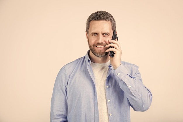 glimlachende man heeft communicatie oproep op telefoon geïsoleerd op studio achtergrond