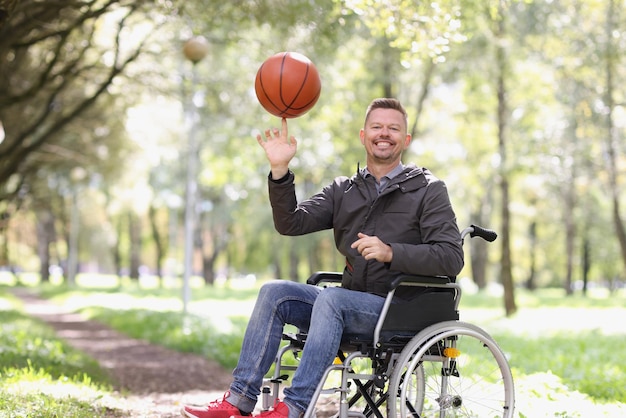 Glimlachende man in rolstoel met basketbalsporten voor mensen met een handicap concept