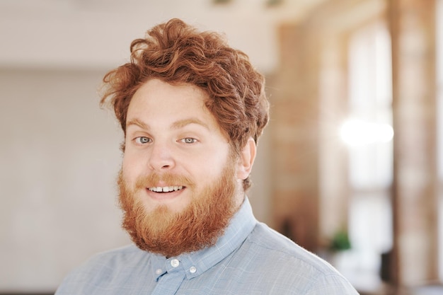 Glimlachende man met een rode baard op kantoor