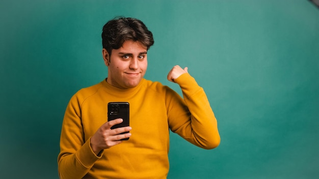 Foto glimlachende man met mobiele telefoon die wegwijst in de studio