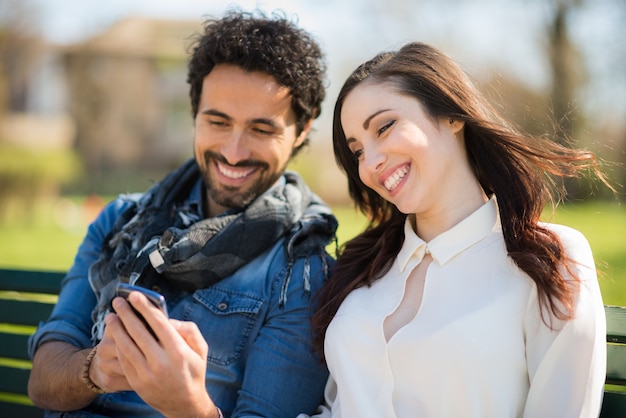 Glimlachende man toont zijn mobiele telefoon aan een meisje