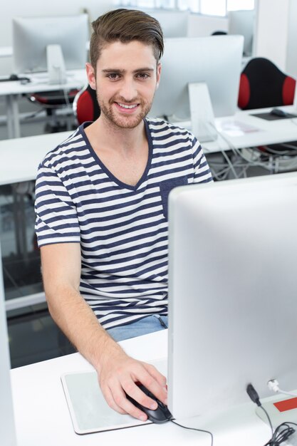 Foto glimlachende mannelijke student in computerklasse