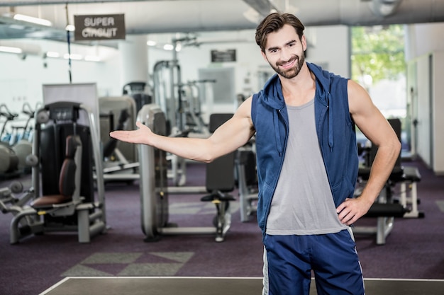 Glimlachende mens die de gymnastiek toont bij de camera