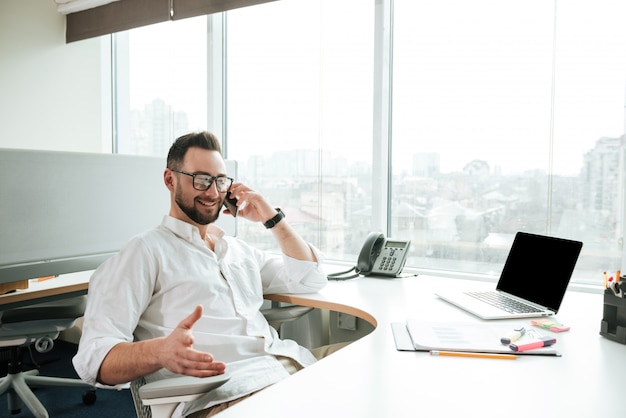 Glimlachende Mens die in overhemd op telefoon spreekt