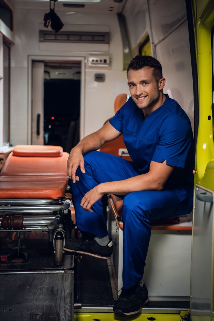 Glimlachende mens in een medische eenvormige zitting in de rug van een ambulanceauto