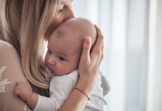 Foto glimlachende moeder die baby thuis vasthoudt