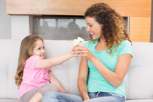 Glimlachende moeder die kleine bloemen van haar dochter krijgt
