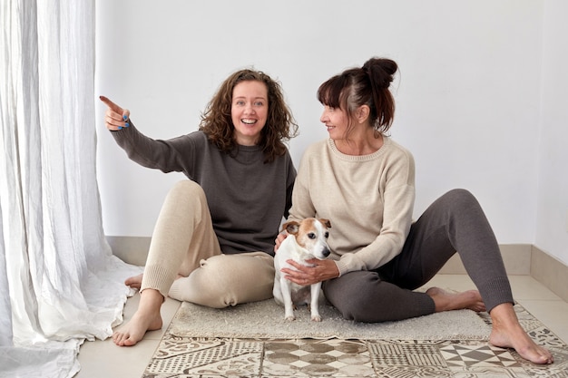 Glimlachende moeder en dochter met hond thuis