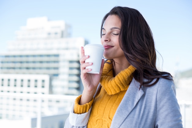 Glimlachende mooie donkerbruine het drinken koffie