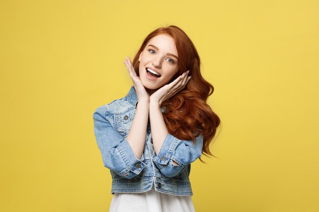 Glimlachende mooie jonge vrouw in de kleren die van Jean met handen op kin stellen.