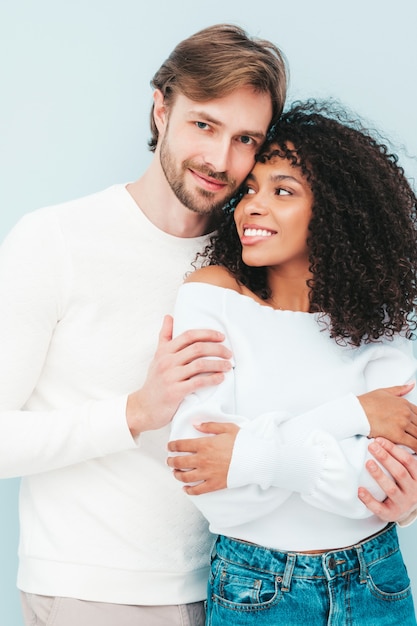 Glimlachende mooie vrouw en haar knappe vriendje. Gelukkige vrolijke multiraciale familie met tedere momenten op grijs