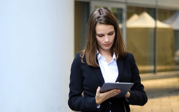 Glimlachende onderneemster die een digitale tablet gebruiken openlucht