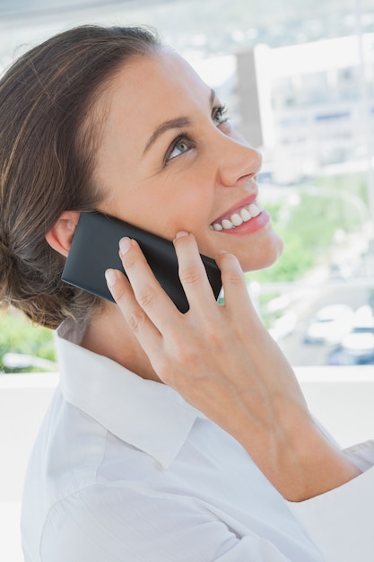 Glimlachende onderneemster die een telefoongesprek heeft