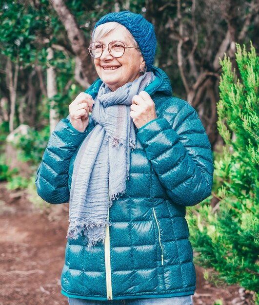 Glimlachende oudere vrouw geniet van vrijheid in de open lucht wandelt in een bergbos Reizen toerisme natuur